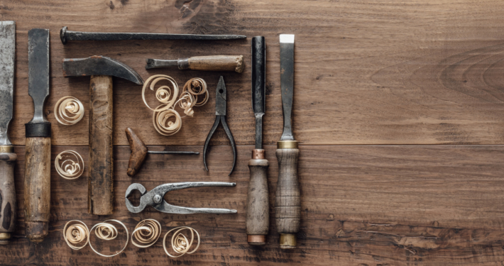 Collection of vintage woodworking tools on a rough workbench and blank copy space: carpentry, craftsmanship and handwork concept, flat lay